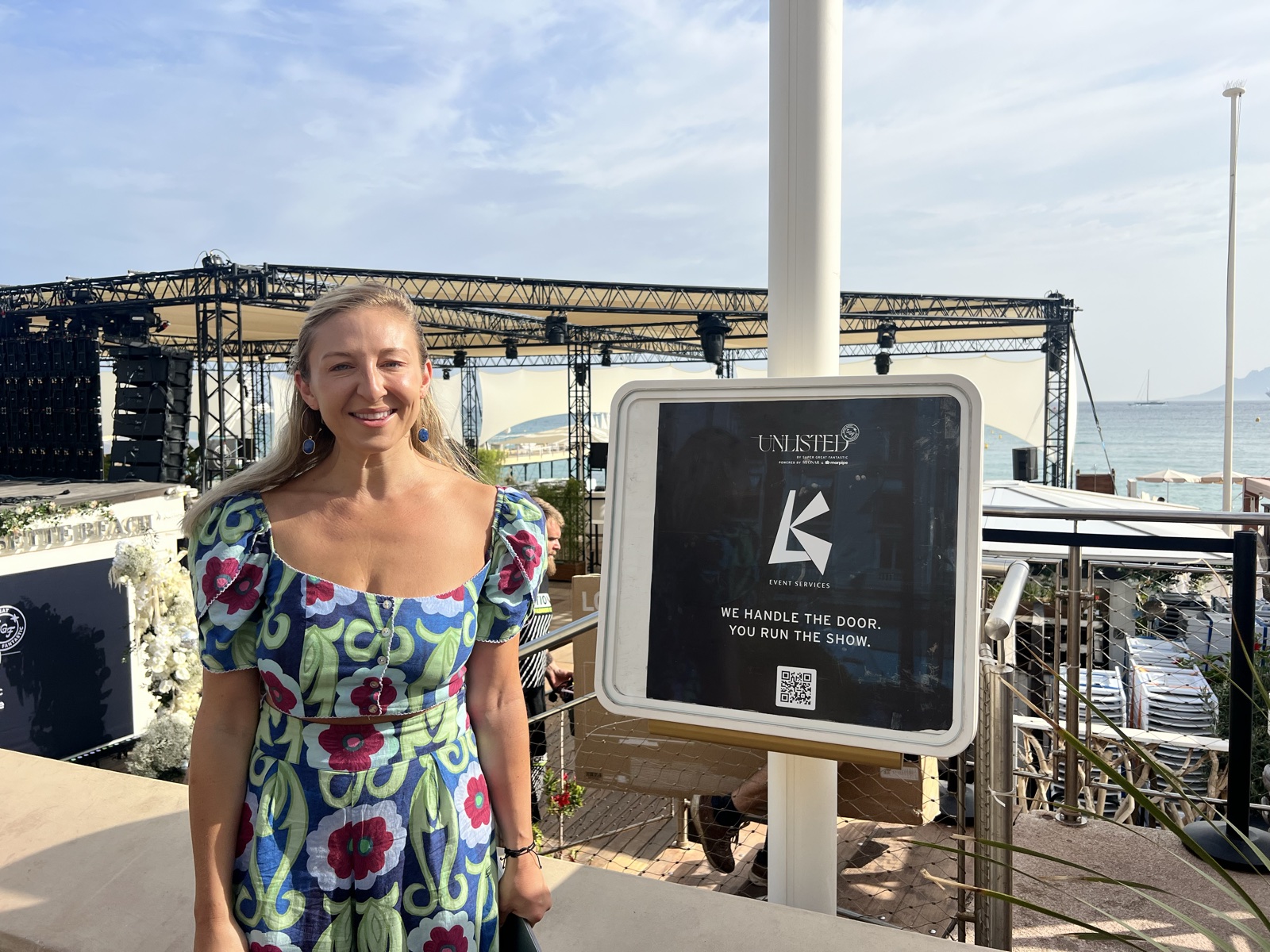 Kristen at the KL Event Services sign on the beach at Cannes Lions.